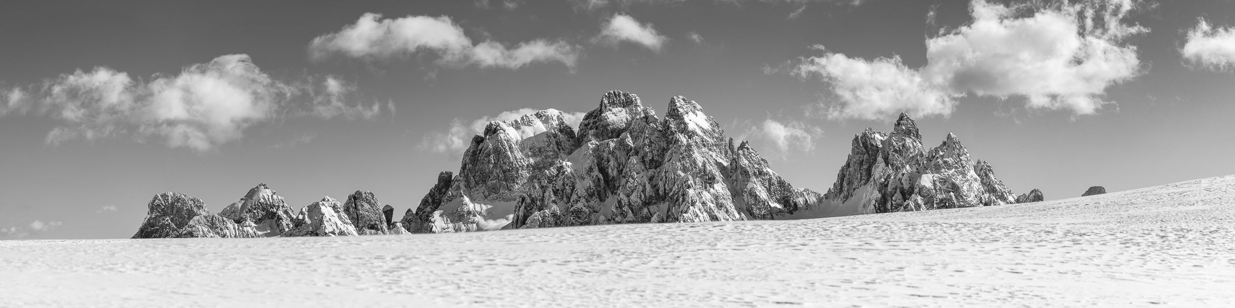 Fotografia in bianco e nero in formato panoramico dei Cadini di Misurina in una splendente giornata invernale